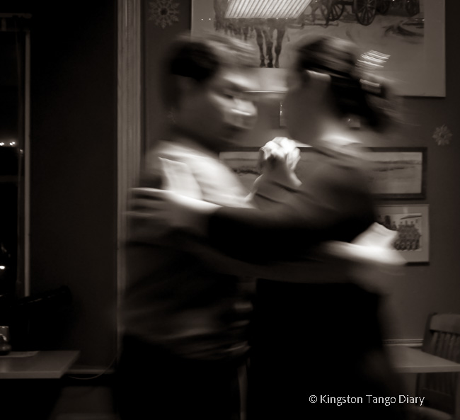 Dancing couple moving through a tango floor.