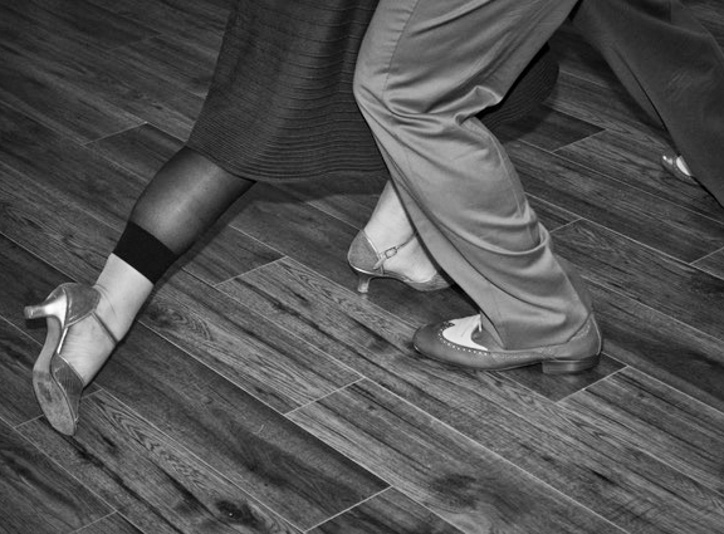 Two pair of feet post an argentine tango movement.